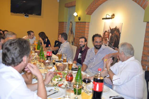 A group of people sitting at a table with wine glasses

Description generated with very high confidence