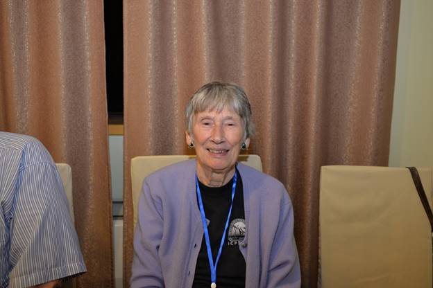 A person sitting in a chair in front of a curtain

Description generated with very high confidence